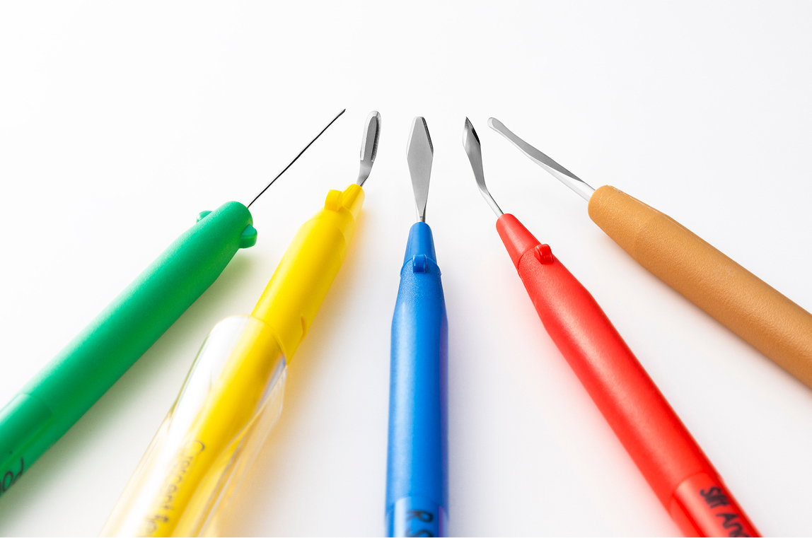 Five types of MANI Ophthalmic Knife with colorful handles (green, yellow, blue, red, brown), displayed in a row on a white background.