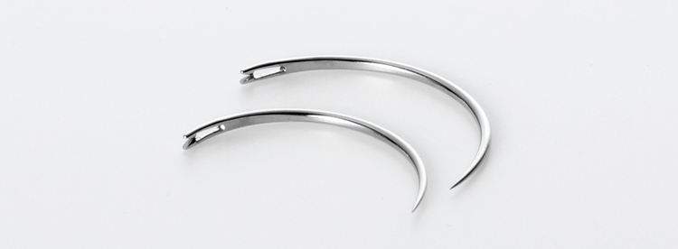 Two MANI Ophthalmic Sutures, curved surgical needles for eye surgery, displayed on a white background
