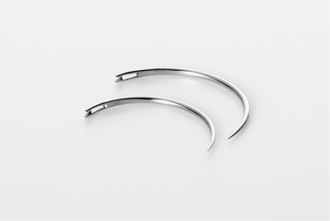 Two MANI Ophthalmic Sutures, curved surgical needles for eye surgery, displayed on a white background